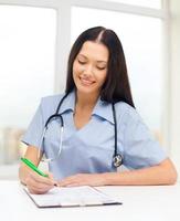 médica ou enfermeira escrevendo prescrição foto