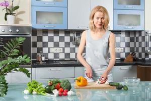 jovem mulher cozinhando. comida saudável - salada de legumes foto
