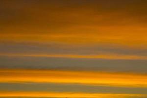 o céu é uma linha horizontal de amarelo-laranja e cores coloridas no lindo entardecer no meio da natureza que é tranquila, quente e romântica no campo e é extremamente bonita. foto