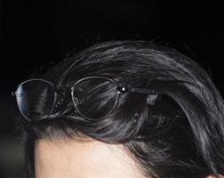 óculos - envoltos na cabeça de uma menina em cima de sua cabeça - na nobre noite descansando - com uma sombra refletindo através dos óculos - de curto prazo. foto