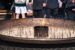 feche o incenso no queimador de incenso que o turista acende incenso para rezar no templo todai-ji em nara, japão. foto