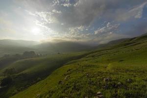 fim de tarde nuvens baixas sobre a montanha foto