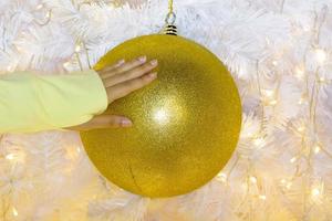 mão de mulher para pegar a bola de natal foto