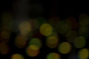 efeitos de luz bokeh abstratos na noite. fundo preto com efeitos de luz coloridos. fundo com efeitos bokeh de desfoque. textura de fundo abstrato foto