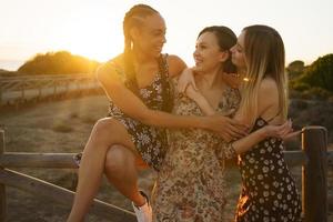 felizes diversas namoradas abraçando perto da cerca foto