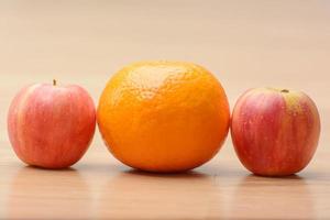 mini maçãs e shogun laranja na mesa de madeira. foto