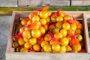 tangerinas frescas em saco de rede de plástico para venda no mercado local. foto