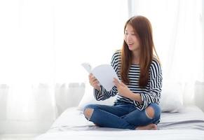 linda de retrato jovem asiática relaxe sentado lendo livro no quarto em casa, literatura de estudo de menina, educação e conceito de estilo de vida. foto