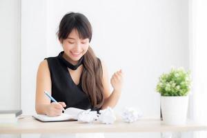 bela jovem escritora asiática animada escrevendo no caderno ou diário com feliz com o sucesso e feliz, estilo de vida garota asiática é estudante, planejamento feminino de trabalho, educação e conceito de negócios.