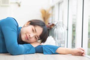 belo retrato jovem mulher asiática sorrindo sentado deitado no café, modelo garota feliz com relaxar e descansar olhando a câmera, conceito de estilo de vida. foto