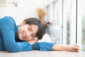 belo retrato jovem mulher asiática sorrindo sentado deitado no café, modelo garota feliz com relaxar e descansar olhando a câmera, conceito de estilo de vida. foto