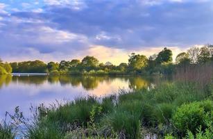bela paisagem por do sol em um lago com uma superfície de água reflexiva foto