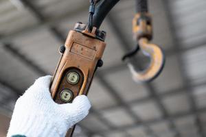 botões de controle industrial. mão segurando guindastes remotos. interruptor do controlador hidráulico para cima e para baixo. interruptor de botão remoto elétrico do elevador de talha ou guindaste para direção de controle. foto