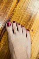 pés de mulheres após pedicure com unhas vermelhas foto