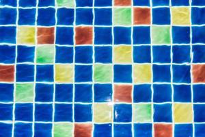 reflexão sobre as ondulações de água azul clara da piscina com fundo de mosaico foto