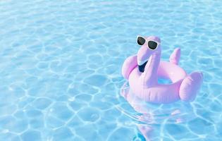 tubo de flamingo com óculos de sol na piscina foto