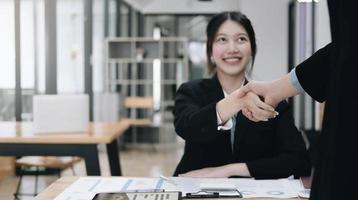 retrato de empresários asiáticos apertando as mãos, terminando a reunião, etiqueta empresarial, parabéns, conceito de fusão e aquisição foto