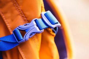 detalhe de close-up de fecho de plástico conveniente azul trancado de mochila amarela. foto