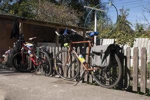 duas bicicletas perto de uma cerca de madeira foto