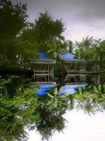 foto de cabeça para baixo reflexo de água clara de duas cabanas de cor azul