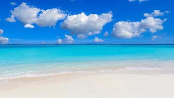 closeup de areia na praia e céu azul de verão. paisagem panorâmica da praia. praia tropical vazia e marinha. nuvens de céu azul brilhante ensolarado, areia macia, calma, sol relaxante tranquilo, clima de verão foto