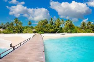 panorama da praia da ilha das maldivas. palmeiras e bar de praia e longo caminho de cais de madeira. férias tropicais e conceito de fundo de férias de verão foto