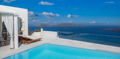 arquitetura branca na ilha de santorini, grécia. piscina em hotel de luxo. bela vista, céu sobre o mar azul. férias de verão e férias como conceito de destino de viagem, incrível fundo de turismo foto