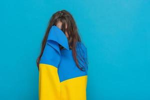 amarelo com tecido azul nos ombros. foto de uma garota em um fundo azul.