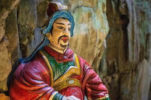 close-up de uma estátua pintada do deus do portão na entrada de uma caverna nas montanhas de mármore em da nang, vietnã