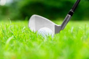 bola de golfe no tee na bela grama no campo de golfe para tiro ao buraco em uma competição com ferro 7 foto