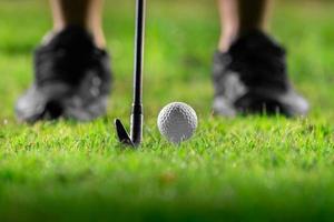 bola de golfe no tee na bela grama no campo de golfe para tiro ao buraco em uma competição com ferro 7 foto
