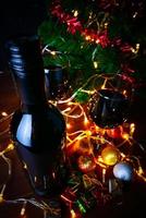 vinho tinto em vidro transparente, árvore de natal e enfeite na mesa de madeira pronta para comemorar.