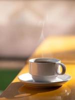 café quente da manhã na mesa de madeira amarela em dia claro foto