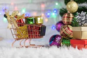 caixa de presente de ouro de fundo de feliz natal com fitas vermelhas e decorações em fundo de algodão de vison branco. vista superior.celebration festival de natal foto