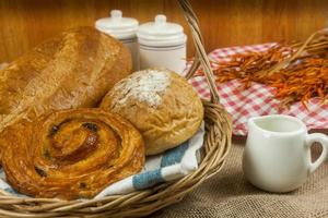 diferentes tipos de pão fresco na mesa de madeira foto