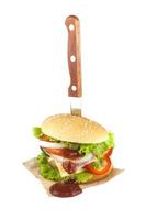 hambúrguer de porco caseiro com bacon grelhado contém legumes, queijo, alface, cebola, pimenta, especiarias em um prato de madeira isolado em backgroud branco foto