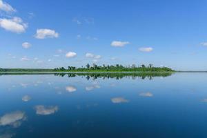 grande ilha no lago. há uma bela nuvem refletindo na água na província de bueng kan da tailândia. foto