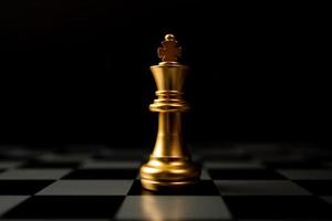 rei de xadrez dourado sozinho no tabuleiro de xadrez foto