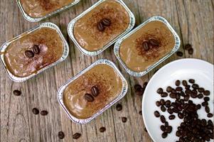 bolo de café em copo de papel alumínio na mesa de madeira foto