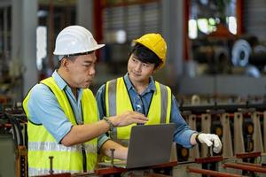equipe de trabalhadores de engenharia asiáticos inspecionando dentro da fábrica de fabricação de aço enquanto ouve os conselhos do gerente sênior sobre a melhoria do conceito de capacidade e produtividade foto