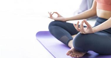 mulher asiática praticando ioga indoor com posição fácil e simples para controlar a inspiração e expiração em pose de meditação foto