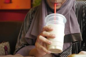 mulheres jovens bebendo milk-shake de banana no café foto