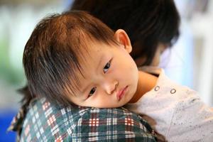 retrato de bebê asiático com sono com a mãe. foto