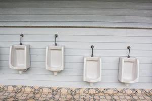 mictórios brancos para homens e meninos no banheiro público foto