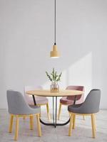 estilo mínimo interior da sala de jantar moderna cadeiras, mesa, vaso de vidro e lâmpada de teto com luz solar no fundo da parede branca renderização em 3d foto