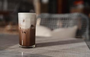 chocolate gelado ou café com leite em vidro na mesa com luz da manhã foto