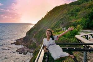 turista de mulher asiática sente-se no assento do terraço líquido na colina com vista foto