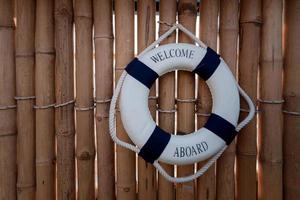 parede de bambu de madeira com anel de salva-vidas azul e branco foto