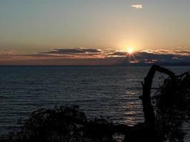 belo pôr do sol sobre o mar na grécia foto