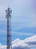 torre de telefone com nuvens brancas ao fundo. foto